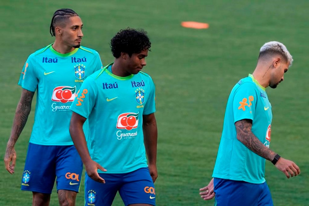 Brazil's Bruno Guimaraes, right, Endrick, center, and Raphinha train ahead of a World Cup 2026 qualifier soccer match against Peru, in Brasilia, Brazil, Sunday, Oct. 13, 2024. (AP Photo/Eraldo Peres)