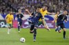 Japan's Kaoru Mitoma and Australia's Cameron Burgess, center, in the air, compete for the ball during the World Cup 2026 Group C qualifying soccer match between Australia and Japan at Saitama Stadium in Saitama, Japan, Tuesday, Oct. 15, 2024. (AP Photo/Eugene Hoshiko)