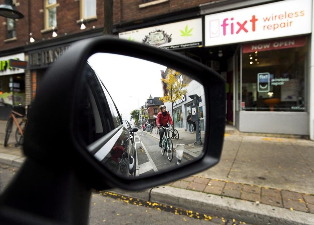 Ontario is planning to make cities ask the province for permission if they want to install bike lanes that would remove lanes of vehicle traffic. Cyclists ride in a bike lane in Toronto on Thursday, October 12, 2017. THE CANADIAN PRESS/Nathan Denette