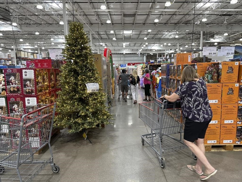 FILE - A shopper passes by a Christmas tree on display in a Costco warehouse on Sept. 12, 2024, in Thornton, Colo. (AP Photo/David Zalubowski, File)