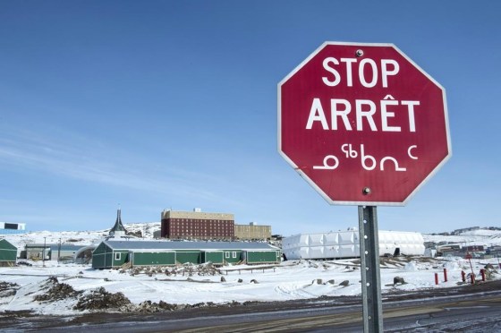 A stop sign in English, French and Inuktut syllabics in Iqaluit. (Paul Chiasson / The Canadian Press files)
