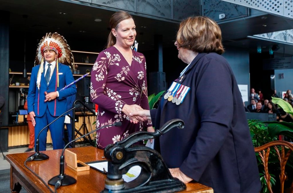 Manitoba Premier Wab Kinew looks on as Tracy Schmidt, Minister of Environment and Climate Change, Minister responsible for Efficiency Manitoba is sworn-in by Lt. Gov. Anita Neville at a Premier and cabinet swearing-in ceremony in Winnipeg, Oct. 18, 2023. After a lengthy review, Manitoba's NDP government has halted a plan hatched by the former Progressive Conservative government to build new schools in partnership with the private sector. THE CANADIAN PRESS/John Woods