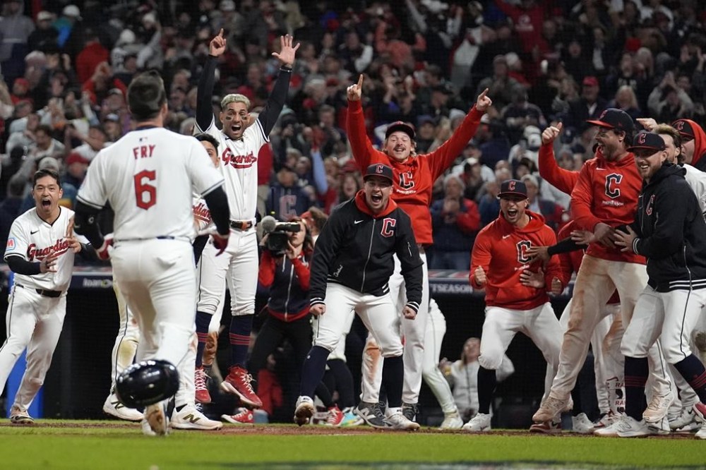Cleveland Guardians players wait for David Fry (6) to cross home plate after hitting a game-winning two-run home run against the New York Yankees during the 10th inning in Game 3 of the baseball AL Championship Series Thursday, Oct. 17, 2024, in Cleveland. The Guardians won 7-5. (AP Photo/Jeff Roberson)
