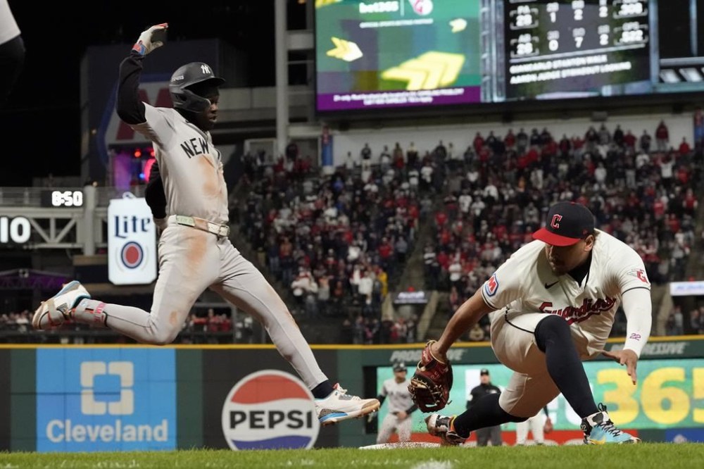 New York Yankees' Jazz Chisholm Jr., left, is out at first as Cleveland Guardians first baseman Josh Naylor stretches to touch the bag during the 10th inning in Game 3 of the baseball AL Championship Series Thursday, Oct. 17, 2024, in Cleveland. (AP Photo/Godofredo Vásquez)
