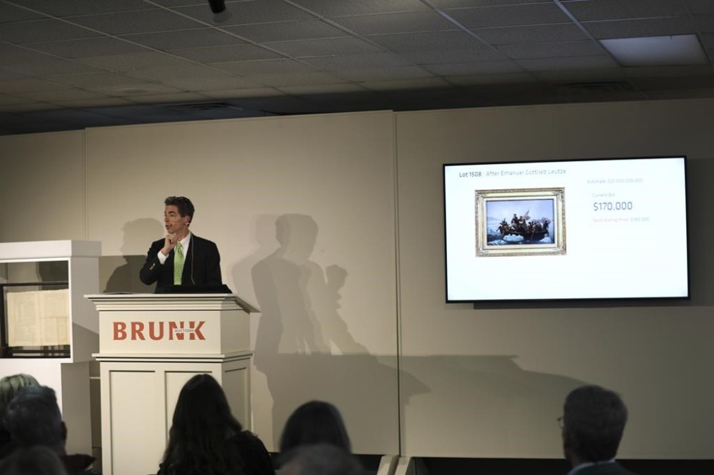 Brunk Auctions owner Andrew Brunk takes bids for a copy of a painting shortly before a 1787 copy of the U.S. Constitution was sold for $9 million in Asheville, N.C., on Thursday, Oct. 17, 2024. (AP Photo/Jeffrey Collins)