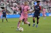 Inter Miami forward Luis Suarez (9) runs with the ball as New England Revolution midfielder Brandon Bye (15) defends during the first half of an MLS soccer match, Saturday, Oct. 19, 2024, in Fort Lauderdale, Fla. (AP Photo/Lynne Sladky)