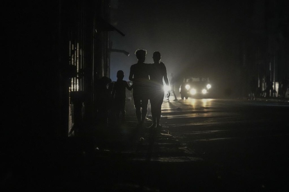 Residents walk on a street during a blackout following the failure of a major power plant in Havana, Cuba, Sunday, Oct. 20, 2024. Another blackout hit Cuba on Wednesday, the latest in a series of outages blamed on aging infrastructure and fuel shortages at power plants. (AP Photo/Ramon Espinosa)