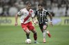 Leandro Gonzalez Pirez of Argentina's River Plate, left, is challenged by Hulk of Brazil's Atletico Mineiro during a Copa Libertadores semifinal first leg soccer match at MRV arena in Belo Horizonte, Brazil, Tuesday, Oct. 22, 2024. (AP Photo/Thomas Santos)