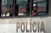 Fans of Uruguay’s Penarol soccer team peer from inside a police bus as they arrive at a police station after being detained for fighting with police on the beach in Rio de Janeiro, Brazil, Wednesday, Oct. 23, 2024. Penarol fans are in Rio for a semi-final Copa Libertadores game against Brazil's Botafogo. (AP Photo/Silvia Izquierdo)