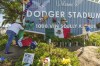 Cristina Vargas from North Hollywood, places a Mexican flag among baseball memorabilia, flowers, and candles placed outside Dodger Stadium after the death of former Dodgers pitcher Fernando Valenzuela Wednesday, Oct. 23, 2024, in Los Angeles. Valenzuela, the Mexican-born phenom for the Los Angeles Dodgers who inspired 