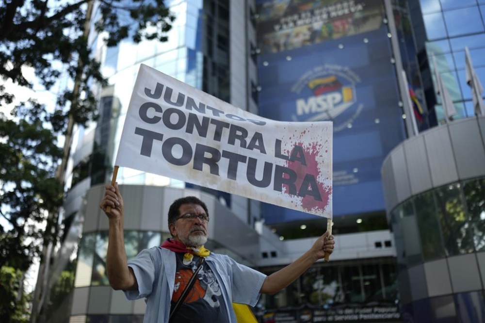 A demonstrator holds a sign that reads in Spanish