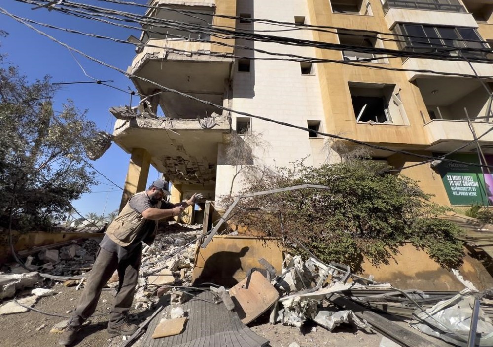 A worker removes the debris of a building that housed the office of pan-Arab TV channel Al-Mayadeen, which is politically allied with Hezbollah, that was hit Wednesday night by an Israeli airstrike, in southern Beirut, Lebanon, Thursday, Oct. 24, 2024. (AP Photo/Hussein Malla)
