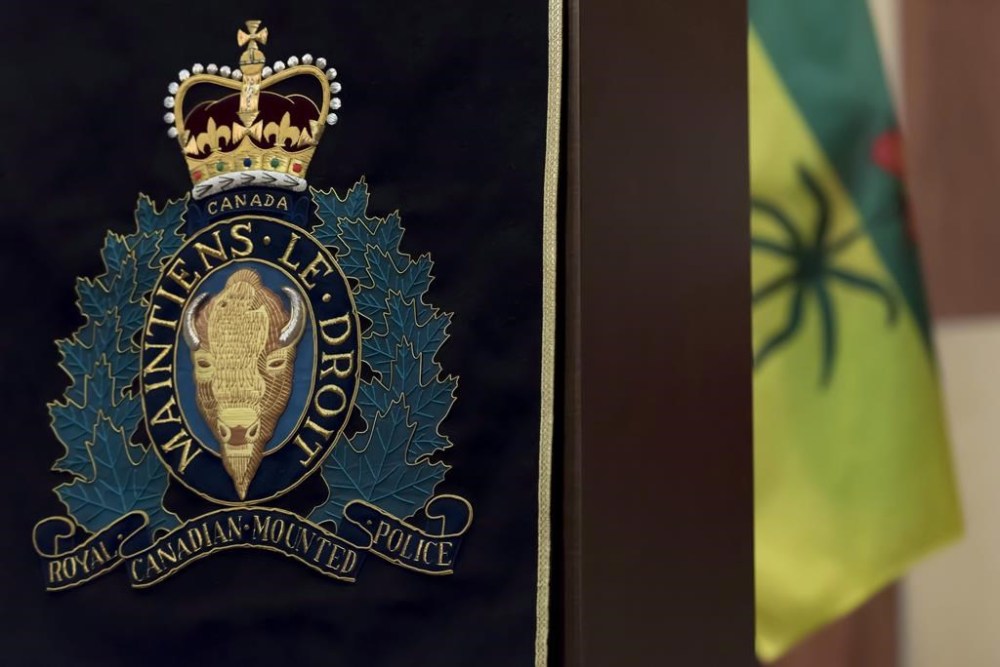 People in a remote area northeast of Saskatoon are being told to take shelter, with police warning of armed and dangerous suspects on the loose. An RCMP insignia hangs from a podium during a press conference at Depot Division in Regina on April 19, 2018. THE CANADIAN PRESS/Michael Bell