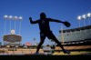 Los Angeles Dodgers' Miguel Rojas warms up during practice in preparation for Game 6 in a baseball NL Championship Series against the New York Mets, Saturday, Oct. 19, 2024, in Los Angeles. (AP Photo/Mark J. Terrill)
