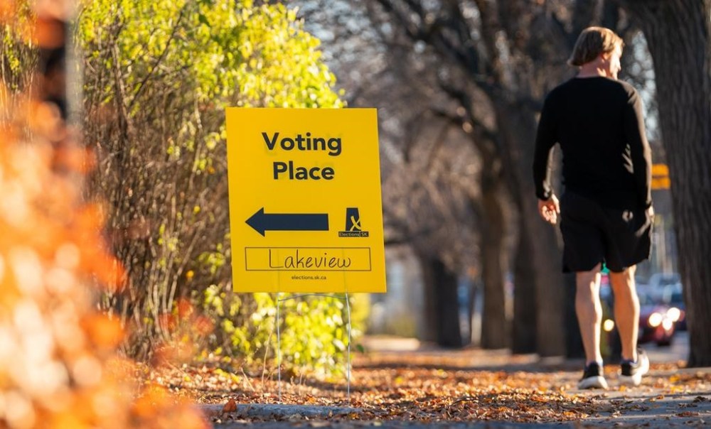 A pedestrian walks past a sign outside a voting place for the Saskatchewan general election in Regina, on Thursday, October 24, 2024. THE CANADIAN PRESS/Heywood Yu