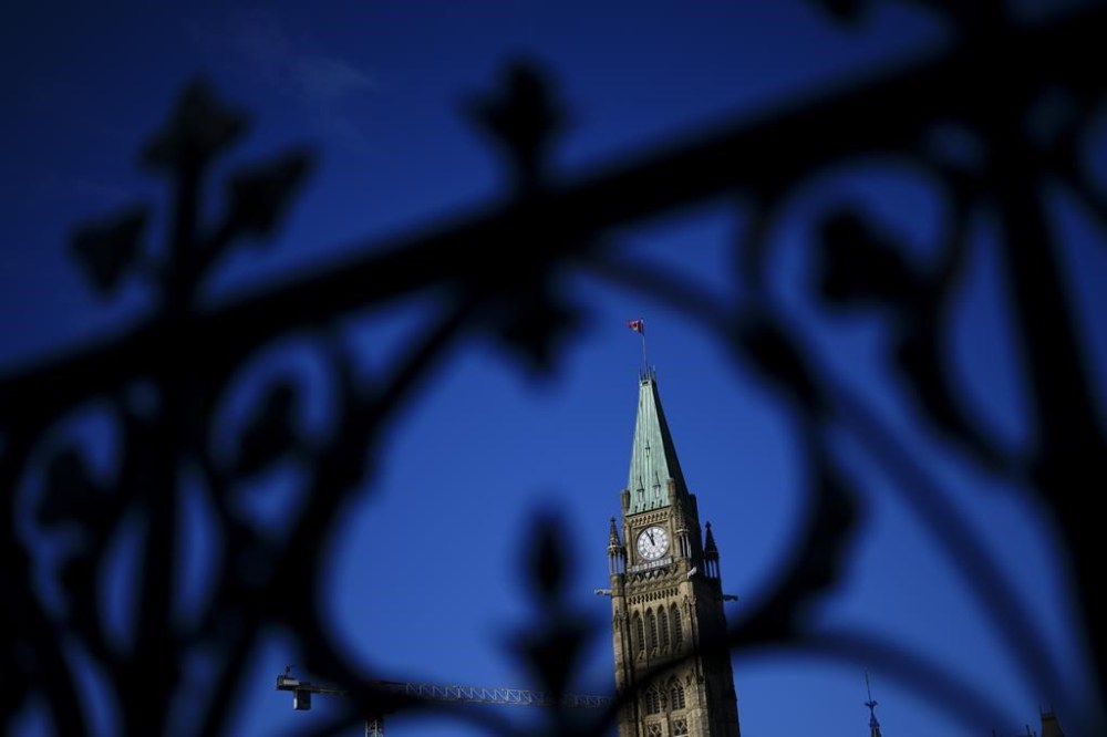 The Peace Tower is framed through the iron railing on Parliament Hill in Ottawa on October 24, 2024. THE CANADIAN PRESS/Sean Kilpatrick