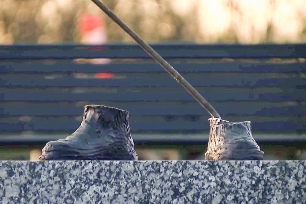 In this image taken from a video provided by WXYZ, only the feet are left of a 600-pound bronze statue of a Tuskegee airman after it was stolen from a city park in Detroit on Friday, October 24, 2024. (WXYZ via AP)