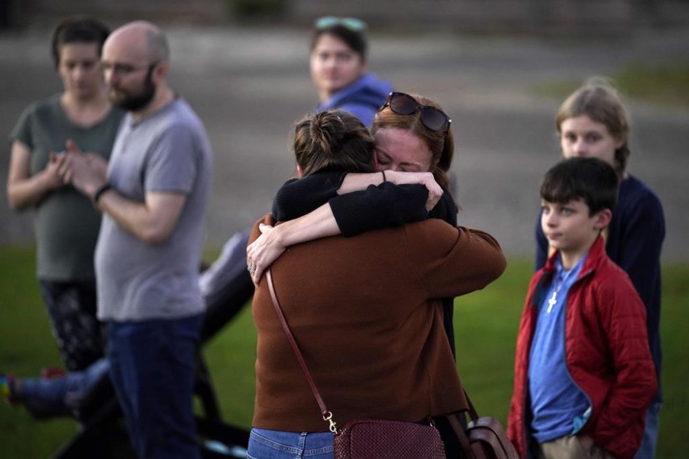 FILE - Lindsay Marlow, facing camera, hugs Courtney Majoros, in this Oct. 28, 2023 file photo, at a vigil in Lisbon Falls, Maine, for the victims of recent mass shootings. Majoros' brother, Maxx Hathaway, was one of the people killed in separate shootings in nearby Lewiston, Maine. (AP Photo/Robert F. Bukaty, File)