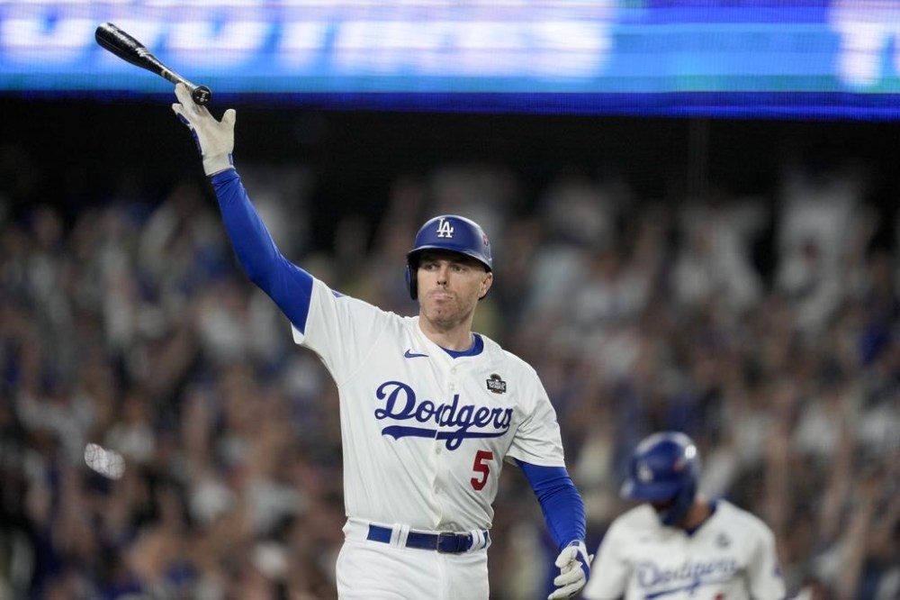 Los Angeles Dodgers' Freddie Freeman celebrates his walk-off grand slam home run against the New York Yankees during the 10th inning in Game 1 of the baseball World Series, Friday, Oct. 25, 2024, in Los Angeles. (AP Photo/Ashley Landis)