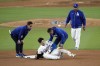 Los Angeles Dodgers' Shohei Ohtani, center, reacts after being injured while trying to steal second base against the New York Yankees during the seventh inning in Game 2 of the baseball World Series, Saturday, Oct. 26, 2024, in Los Angeles. (AP Photo/Julio Cortez)