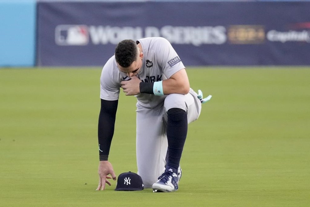 New York Yankees' Aaron Judge kneels in the outfield before Game 2 of the baseball World Series against the Los Angeles Dodgers, Saturday, Oct. 26, 2024, in Los Angeles. (AP Photo/Mark J. Terrill)