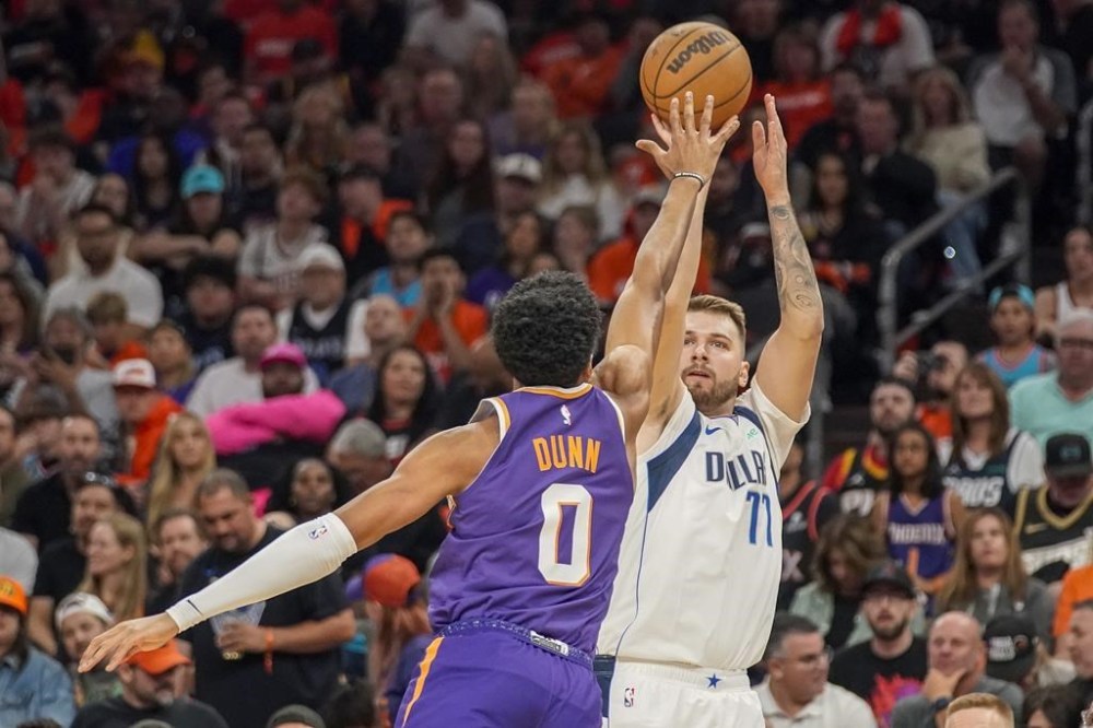 Dallas Mavericks guard Luka Doncic (77) shoots over Phoenix Suns forward Ryan Dunn (0) during the first half of an NBA basketball game Saturday, Oct. 26, 2024, in Phoenix. (AP Photo/Darryl Webb)