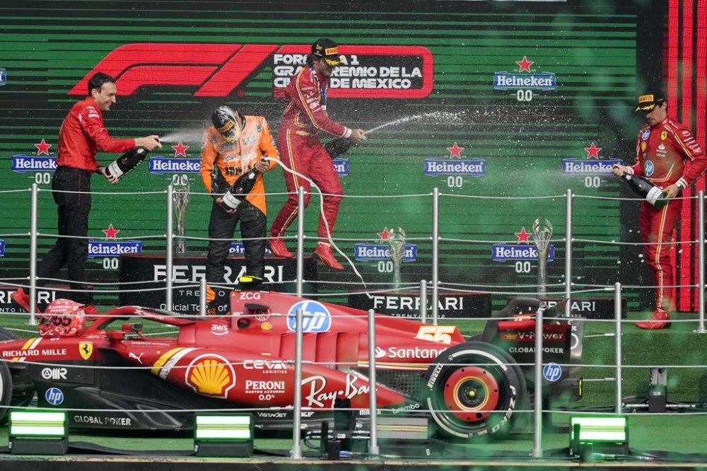 Ferrari driver Carlos Sainz of Spain, first place, center, Charles Leclerc of Monaco, third place, right, Riccardo Adami of Ferrari, left, and McLaren driver Lando Norris of Britain, second place, celebrate at the podium for the Formula One Mexico Grand Prix auto race at the Hermanos Rodriguez racetrack in Mexico City, Sunday, Oct. 27, 2024. (AP Photo/Eduardo Verdugo)