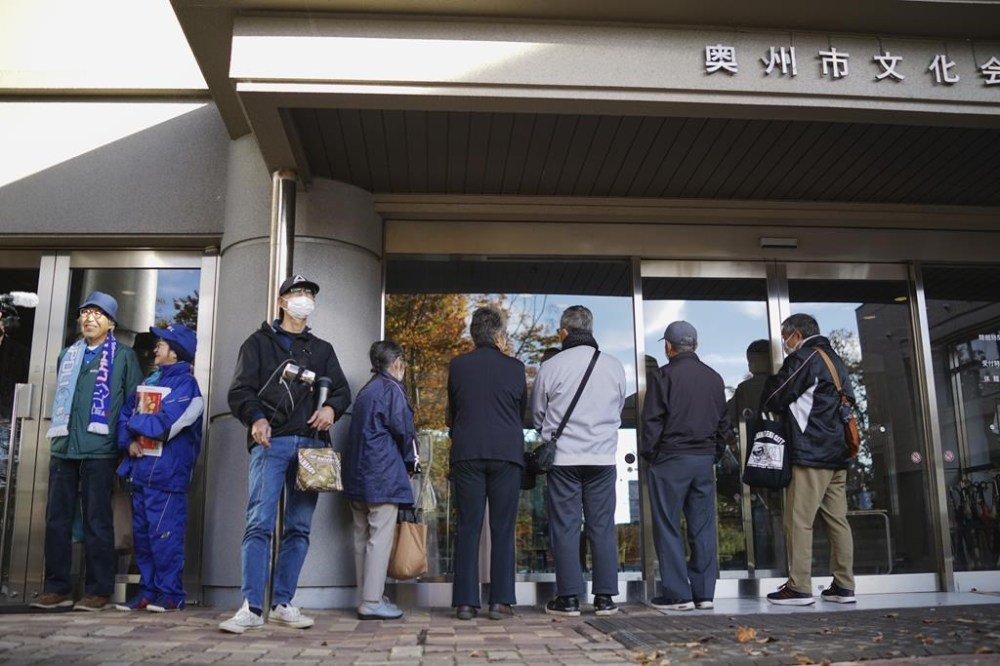 People wait in line to watch a live stream of Game 3 of the baseball World Series between the Los Angeles Dodgers and the New York Yankees, in a public viewing event in Oshu, northeastern Japan, the hometown of Shohei Ohtani of the Dodgers, Tuesday,Oct. 29, 2024. (AP Photo/Eugene Hoshiko)