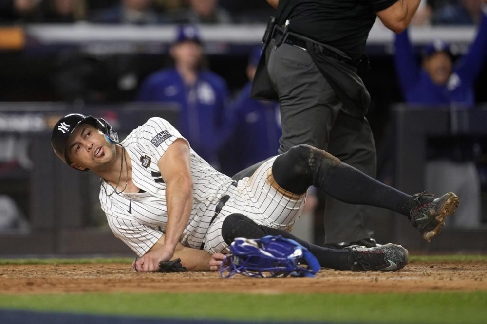 New York Yankees' Giancarlo Stanton lies on the ground after being tagged out while trying to score against the Los Angeles Dodgers during the fourth inning in Game 3 of the baseball World Series, Monday, Oct. 28, 2024, in New York. (AP Photo/Godofredo A. Vásquez)