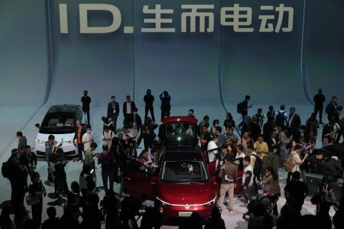 FILE - Attendees take a close look at the Volkswagen ID.7 Vizzion, a new electric flagship sedan during a world premiere on the eve of the Auto Shanghai 2023 show in Shanghai, China, April 17, 2023. (AP Photo/Ng Han Guan, File)