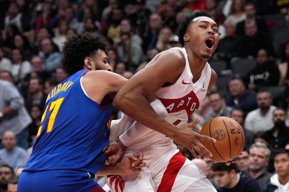 Toronto Raptors forward Scottie Barnes (4) grimaces as he drives into Denver Nuggets guard Jamal Murray (27) during first half NBA basketball action in Toronto, Monday, Oct. 28, 2024. THE CANADIAN PRESS/Nathan Denette