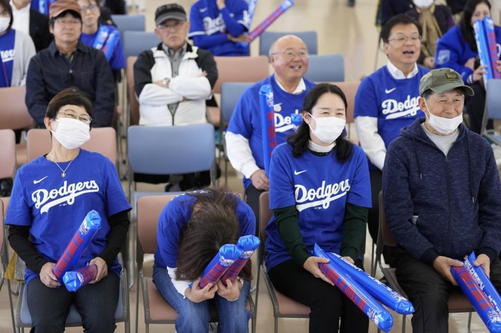 People react as they watch a live view of Game 4 of the baseball World Series between the Los Angeles Dodgers and the New York Yankees during a public viewing event in Oshu, northeastern Japan, the hometown of Shohei Ohtani of the Dodgers, Wednesday, Oct. 30, 2024. (AP Photo/Eugene Hoshiko)