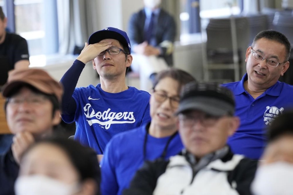 People react as they watch a live view of Game 4 of the baseball World Series between the Los Angeles Dodgers and the New York Yankees during a public viewing event in Oshu, northeastern Japan, the hometown of Shohei Ohtani of the Dodgers, Wednesday, Oct. 30, 2024. (AP Photo/Eugene Hoshiko)