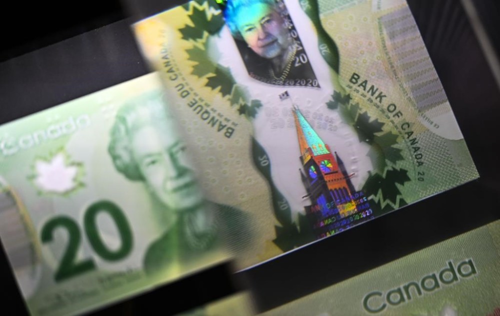 A magnifying glass enlarges the holographic image of Parliament Hill's Peace Tower on a $20 bill issued by the Bank of Canada, shown in a display case at the Bank of Canada Museum in Ottawa, Wednesday, Sept. 4, 2024. THE CANADIAN PRESS/Justin Tang