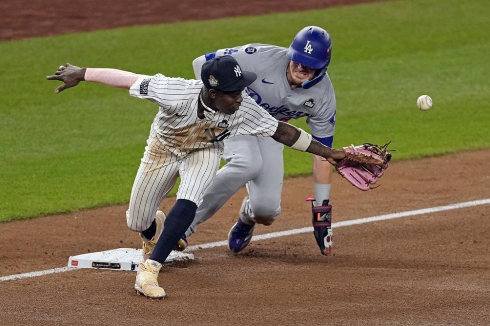 Los Angeles Dodgers' Kiké Hernández, right, is safe at third as New York Yankees third baseman Jazz Chisholm Jr. reaches for a throw from shortstop Anthony Volpe during the fifth inning in Game 5 of the baseball World Series, Wednesday, Oct. 30, 2024, in New York. Volpe was charged with a throwing error. (AP Photo/Seth Wenig)