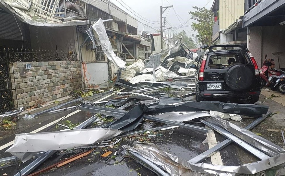 In this photo released by Hualien County Fire Department, a blown roof destroyed by the wind of Typhoon Kong-rey, lay across a road in Hualien County, eastern Taiwan, Thursday, Oct. 31, 2024. (Hualien County Fire Department via AP)