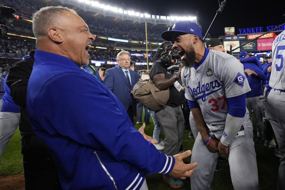 Los Angeles Dodgers manager Dave Roberts and Teoscar Hernández celebrate their win against the New York Yankees in Game 5 to win the baseball World Series, Wednesday, Oct. 30, 2024, in New York. (AP Photo/Ashley Landis)