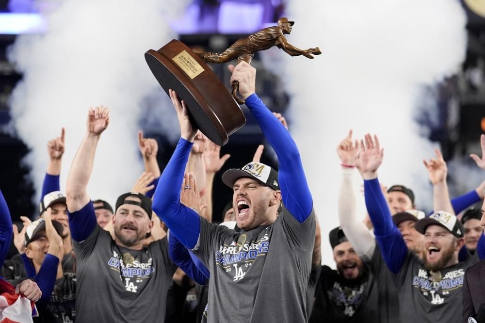 Los Angeles Dodgers' Freddie Freeman celebrates with the MVP trophy after their win against the New York Yankees in Game 5 to win the baseball World Series, Thursday, Oct. 31, 2024, in New York. (AP Photo/Ashley Landis)