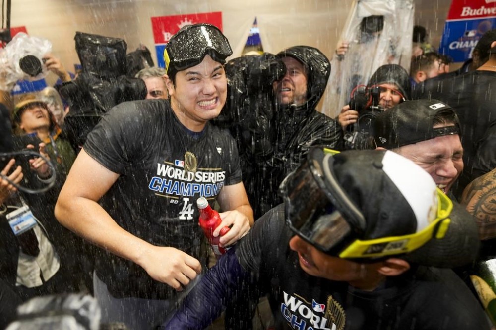 Los Angeles Dodgers' Shohei Ohtani celebrates in the locker room after their win against the New York Yankees in Game 5 to win the baseball World Series, Thursday, Oct. 31, 2024, in New York. (AP Photo/Ashley Landis)