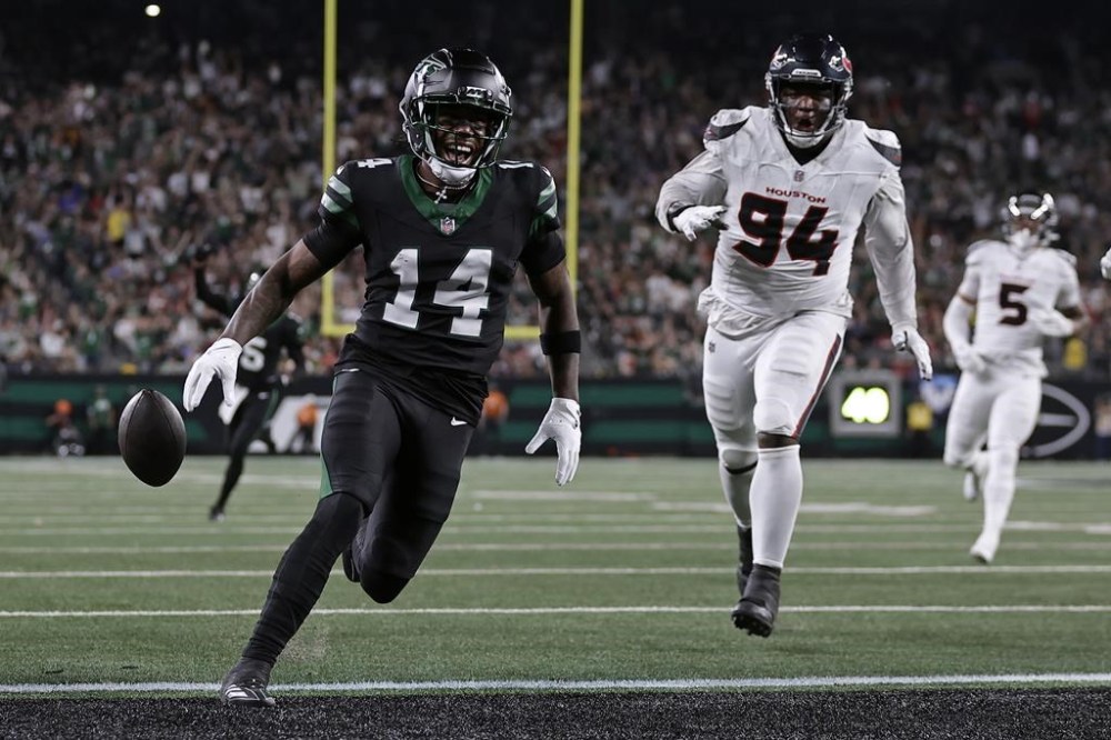 New York Jets wide receiver Malachi Corley (14) drops the ball short of the goal line in front of Houston Texans defensive tackle Khalil Davis (94) during an NFL football game Thursday, Oct. 31, 2024, in East Rutherford, N.J. (AP Photo/Adam Hunger)