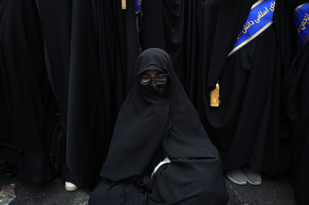 An Iranian woman sits as she attends an annual rally in front of the former U.S. Embassy in Tehran, Iran, Sunday, Nov. 3, 2024, marking the 45th anniversary of Iranian students' takeover of the embassy, starting a hostage crisis. (AP Photo/Vahid Salemi)