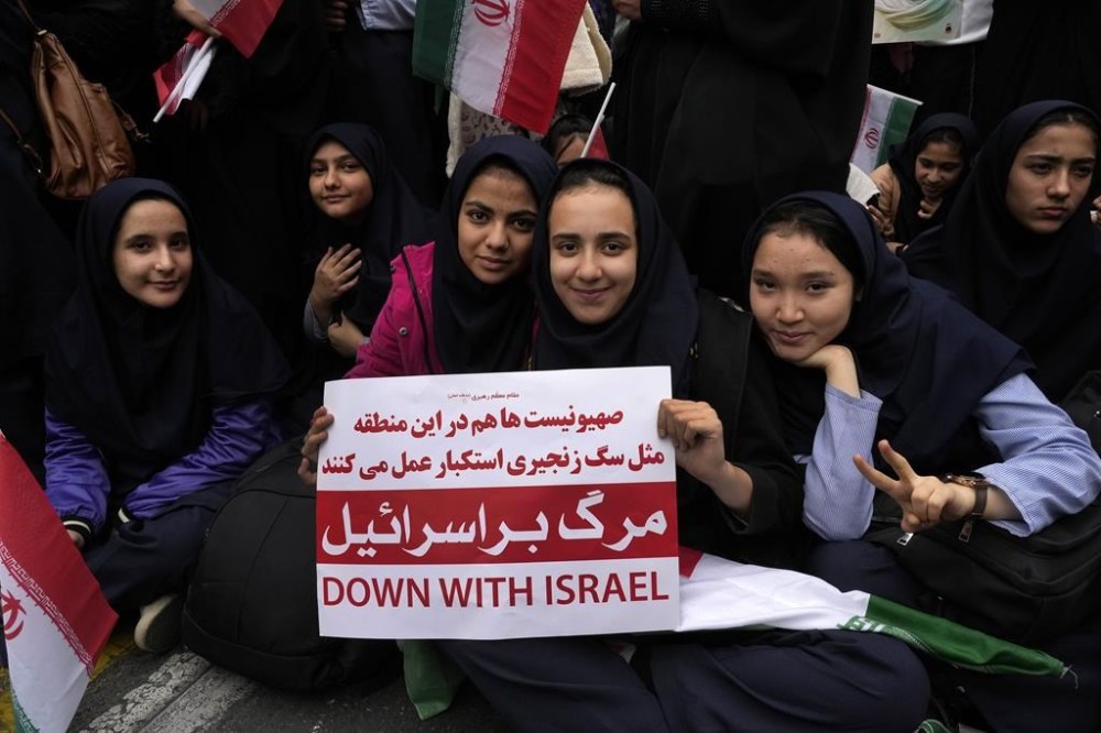 An Iranian schoolgirl holds an anti-Israeli placard during an annual rally in front of the former U.S. Embassy in Tehran, Iran, Sunday, Nov. 3, 2024, marking the 45th anniversary of Iranian students' takeover of the embassy, starting a hostage crisis. (AP Photo/Vahid Salemi)