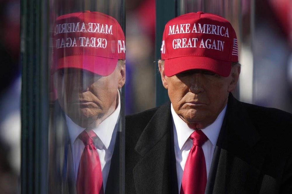 Republican presidential nominee former President Donald Trump is reflected in the bullet proof glass as he finishes speaking at a campaign rally in Lititz, Pa., Sunday, Nov. 3, 2024. (AP Photo/Matt Rourke)
