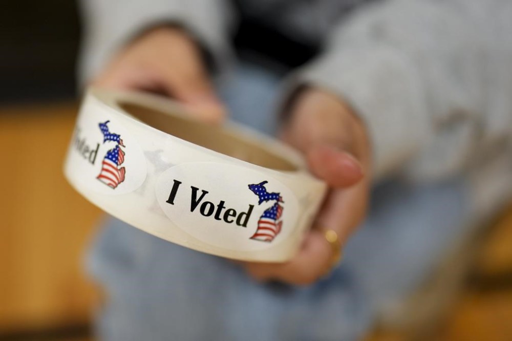 A poll worker holds a roll of