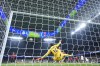 AC Milan's goalkeeper Mike Maignan stops a ball during the Champions League opening phase soccer match against Real Madrid at the Santiago Bernabeu stadium in Madrid, Spain, Tuesday, Nov. 5, 2024. (AP Photo/Manu Fernandez)