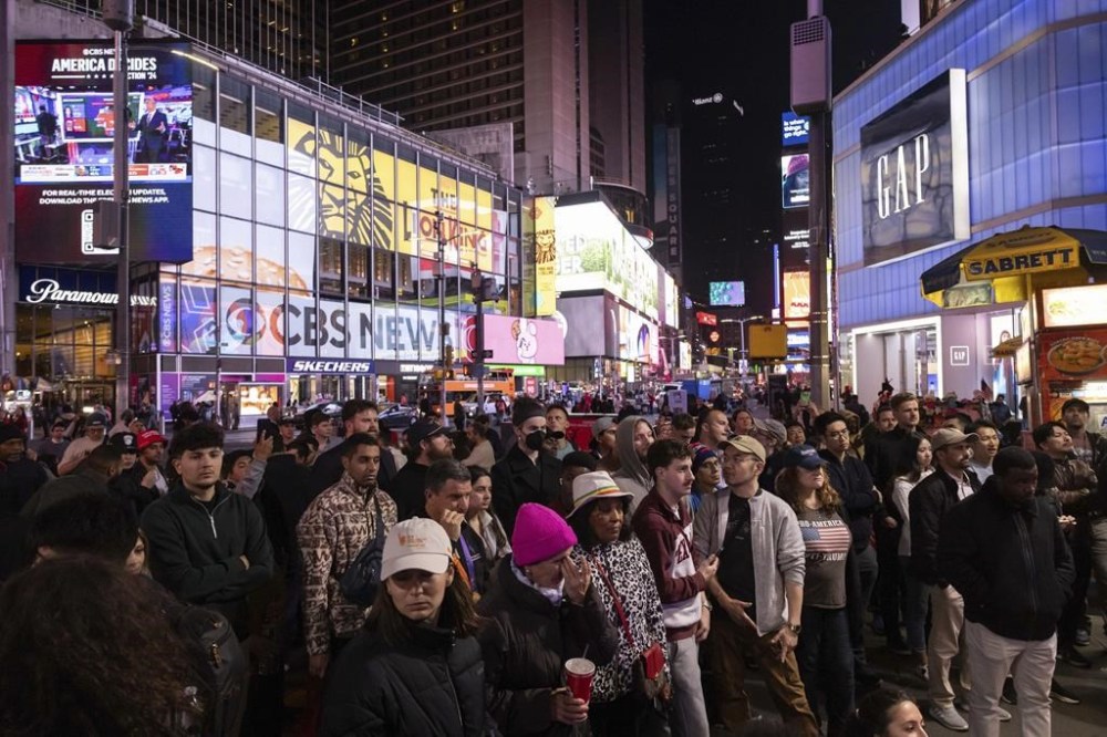 People watch an ABC News livestream showing poll results in Times Square in New York, Wednesday, Nov. 6, 2024. (AP Photo/Yuki Iwamura)
