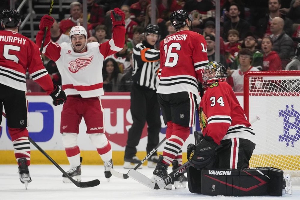 Detroit Red Wings right wing Alex DeBrincat, left, celebrates after scoring on Chicago Blackhawks goaltender Petr Mrazek during the first period of an NHL hockey game Wednesday, Nov. 6, 2024, in Chicago. (AP Photo/Erin Hooley)