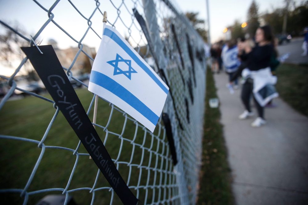 JOHN WOODS / FREE PRESS
People pin ribbons with victims' names to a fence during a memorial in Winnipeg in support of victims of the Oct. 7 attack.