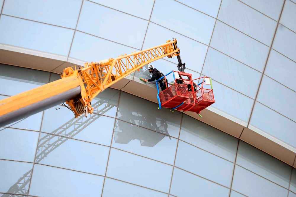 Because of the unique angles of the museum’s design, the job can only be done with the use of a crane and bucket. (Ruth Bonneville / Free Press)