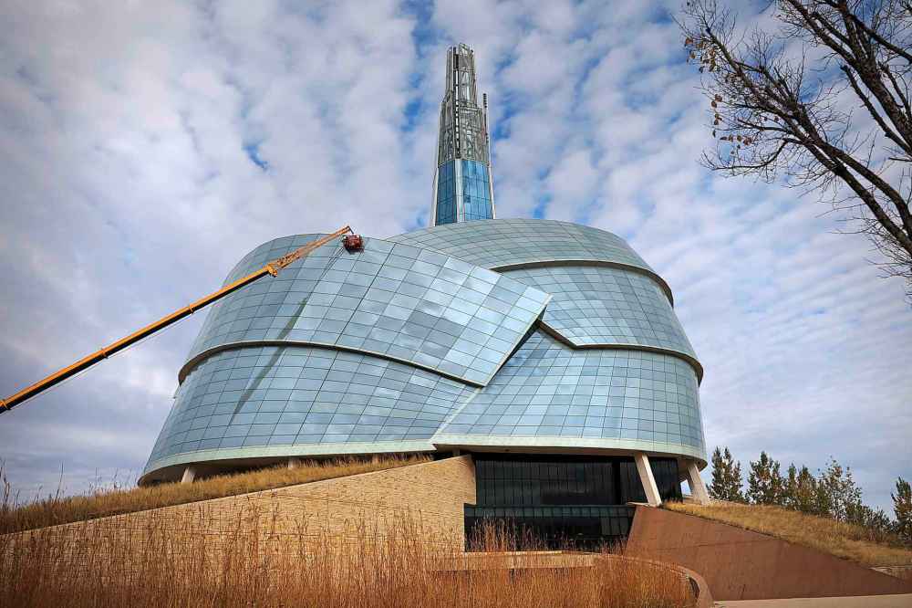 A crane looms 40 metres over the glass of the CMHR. (Ruth Bonneville / Free Press)